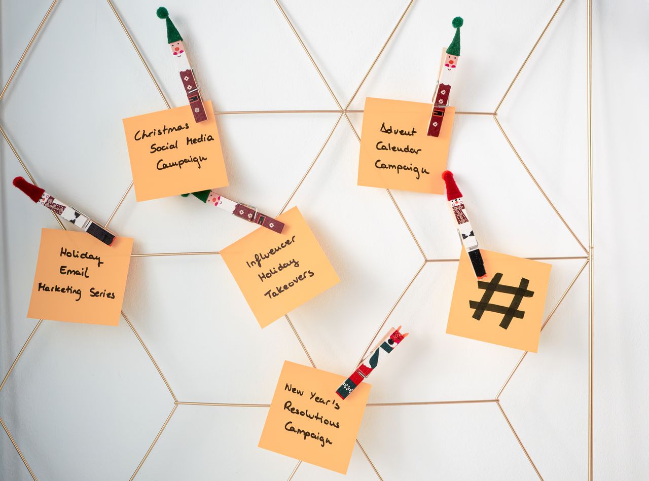 Des notes autocollantes avec des idées de marketing pour les fêtes, fixées sur une grille murale.